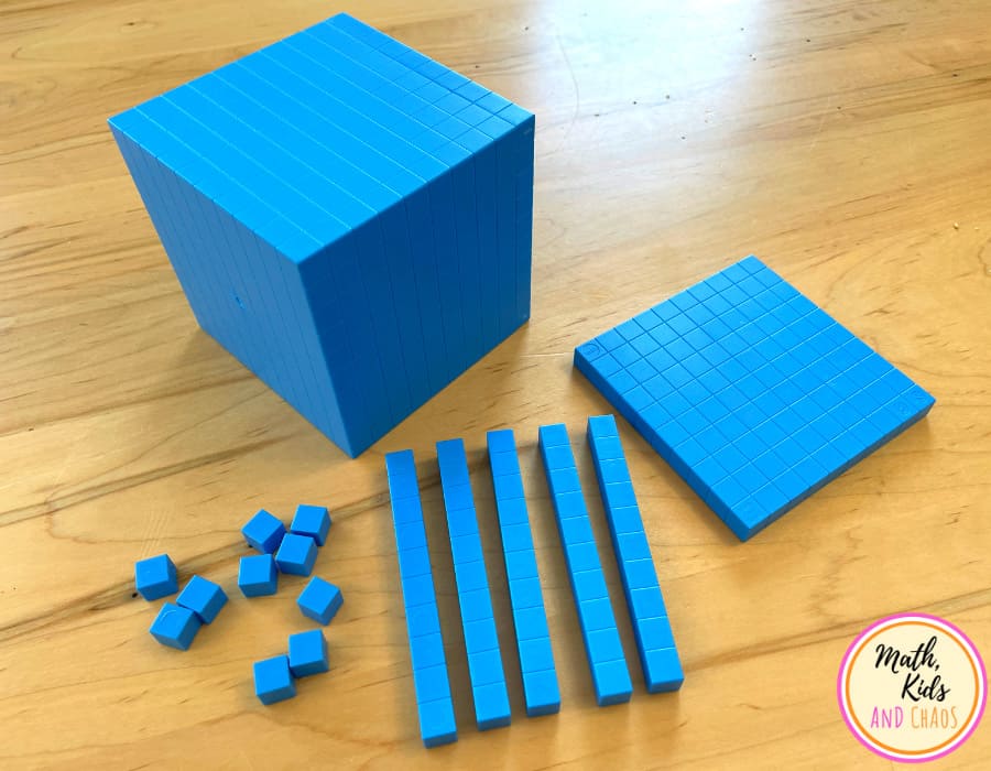 one thousand cube, one flat, 5 rods and 10 units on a wooden table top